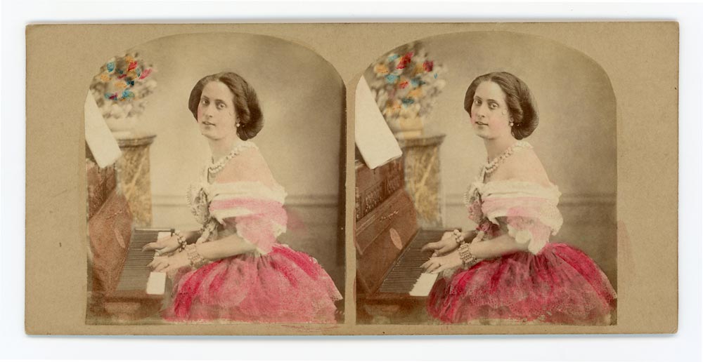 Vintage hand tinted stereo card of a woman playing the piano