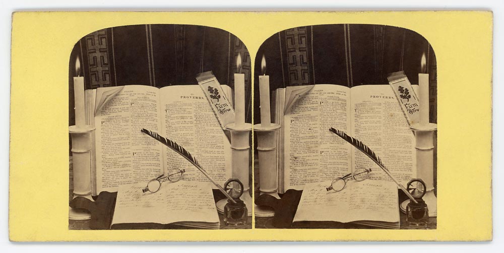 Vintage stereo card still life with an open book, glasses and quill pen