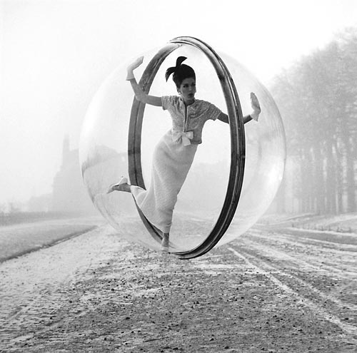 Fashion model floating in a bubble over Paris street