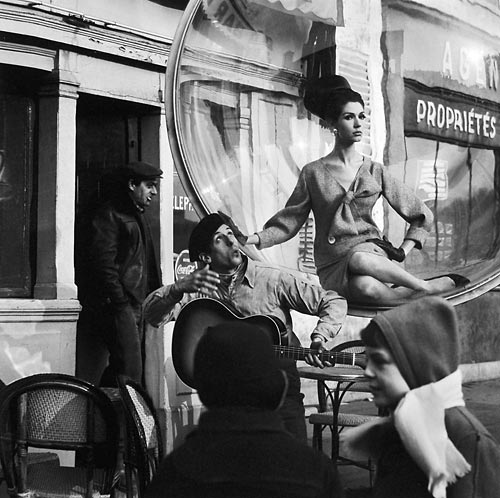 Fashion model floating in a bubble in front of a Paris cafe
